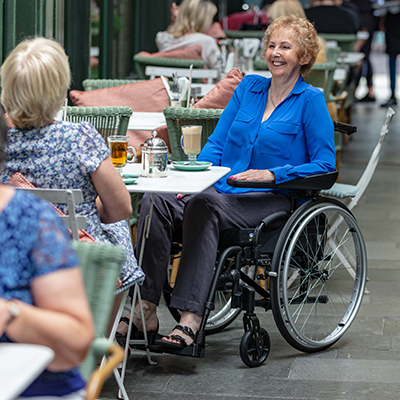 Invacare kørestol - Action 3NG med hemiarmlæn - ældre kvinde i kørestol - smil - senior - pensionist - hjælpemilder til ældre og handicappede