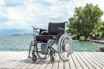 Alber e-fix hjælpemotor på manuel kørestol ved strand på bro